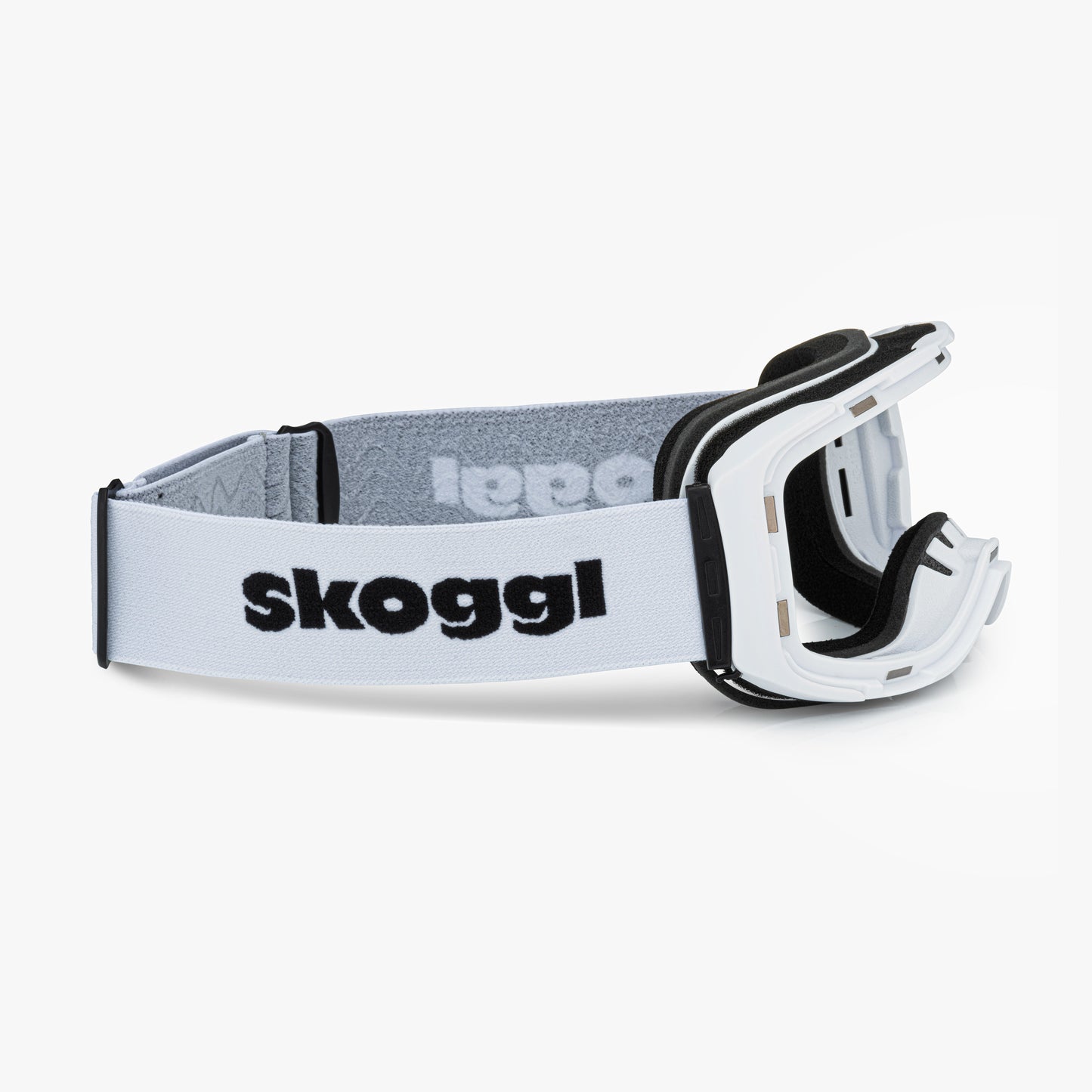 White ski and snowboard goggle frames with black interior padding and an adjustable White strap featuring the brand name 'Skoggl' in black letters. Shown without lenses to highlight the magnetic lens slot, set against a plain white background. Perfect for customizable, high-performance ski and snowboard gear.