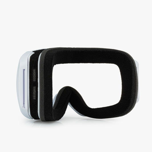 White ski goggles frame are shown against a white background. The goggles have a soft foam lining for comfort around the eyes. The image highlights the strap ports for interchangeable straps and the soft foam padding for comfort.