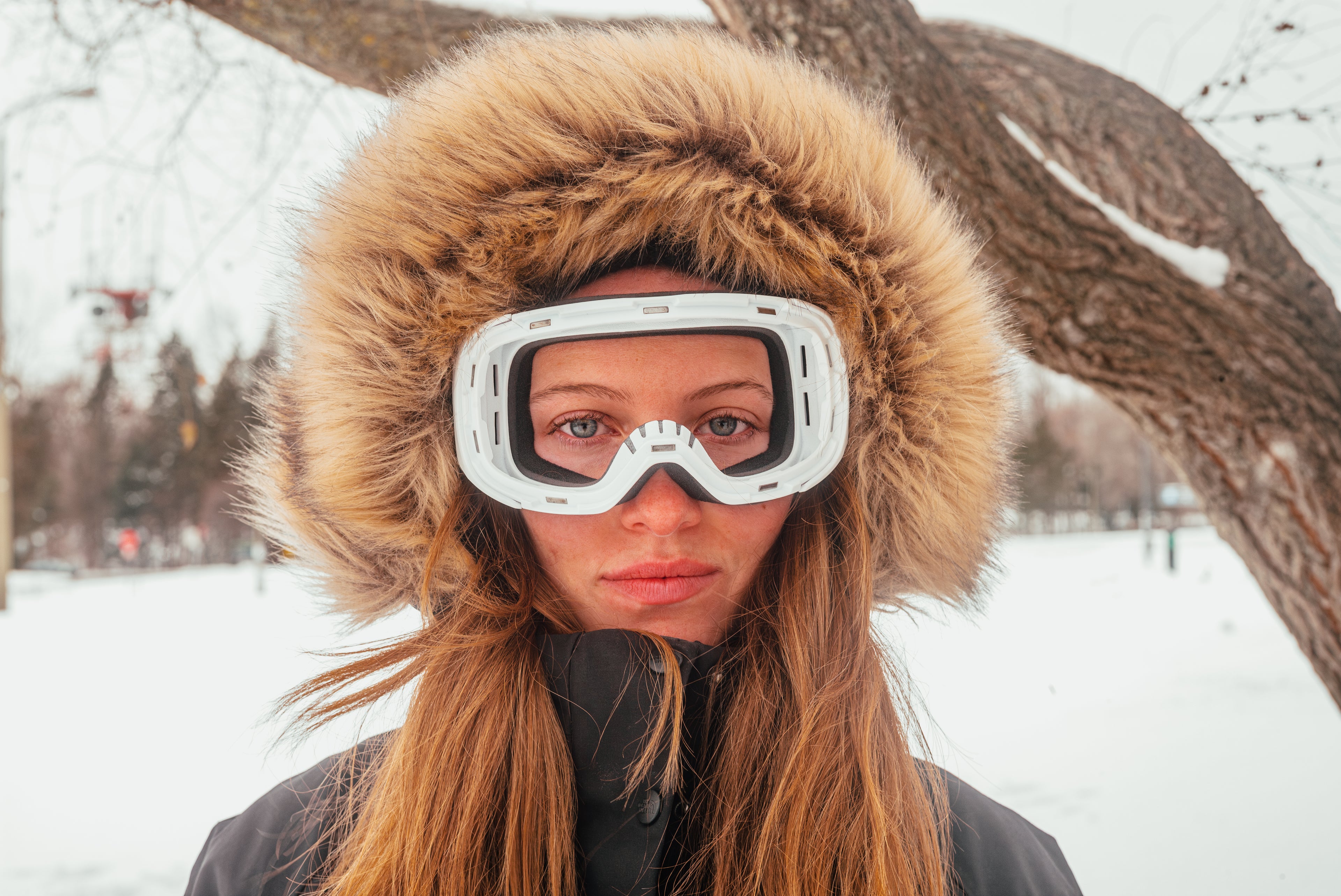 Model wearing a ski goggle frame without lenses, highlighting the magnetic, interchangeable design for easy customization.