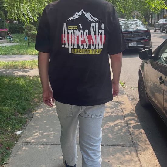 Model walking down a city road wearing the black ovrersized Skoggl Après Ski Team Tee on the back of the tee.