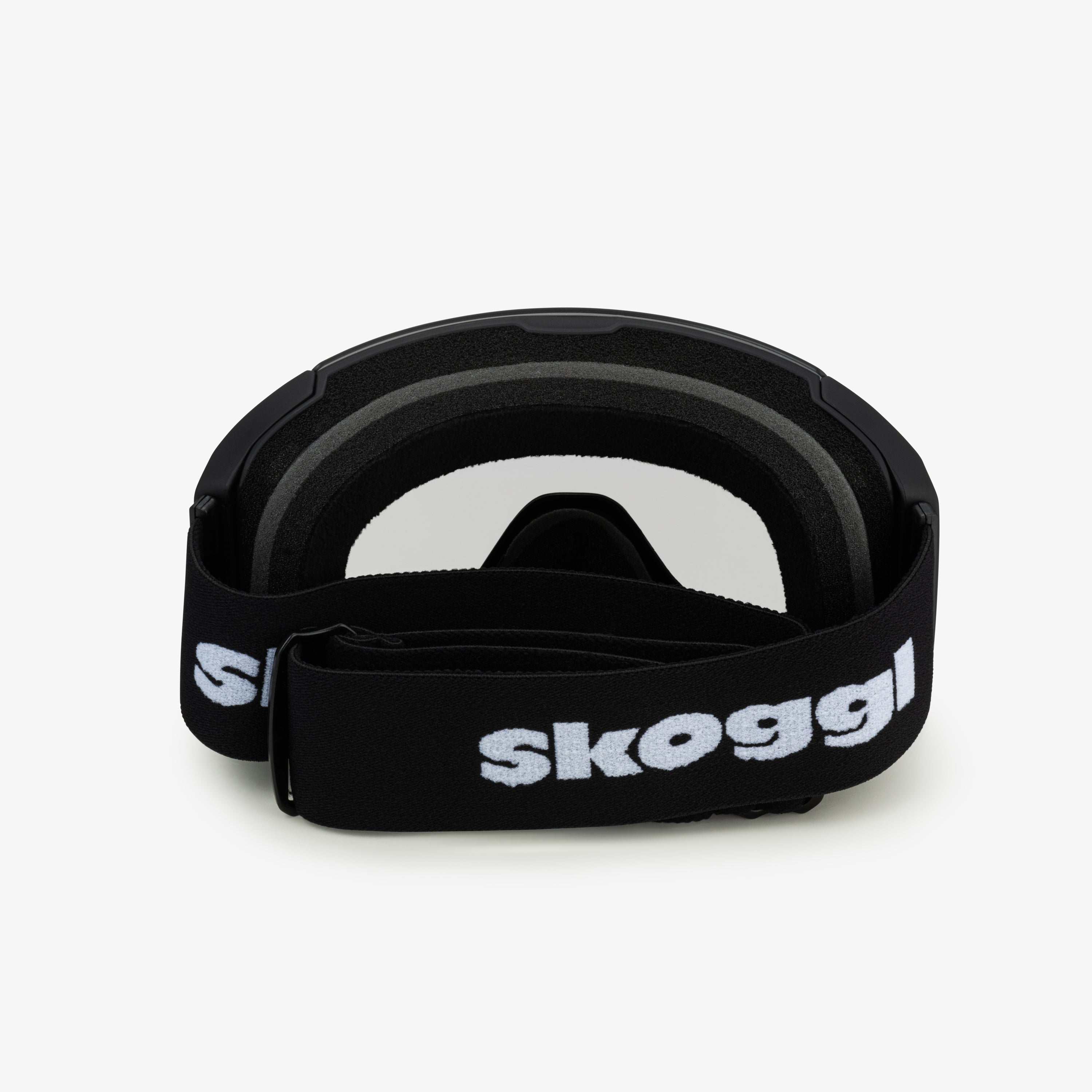 Black ski and snowboard goggles with a wide black strap featuring the word 'Skoggl', shown from the back. Clear lenses are visible through the frame, paired with black cushioning for comfort and a secure fit. Perfect for customizable, stylish ski and snowboard gear designed for performance on the slopes.