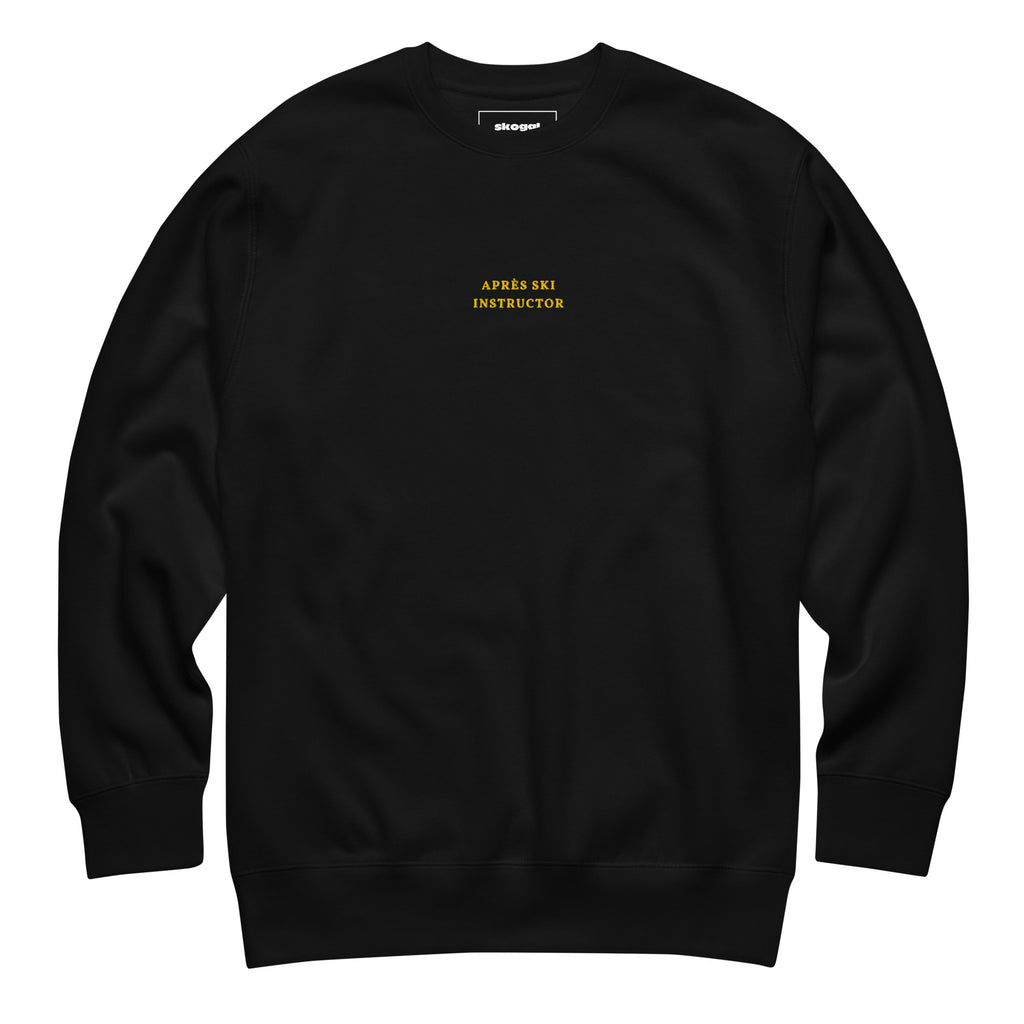 Black Skoggl Après Ski Instructor sweatshirt with yellow embroidered chest text, fleece-lined for warmth.
