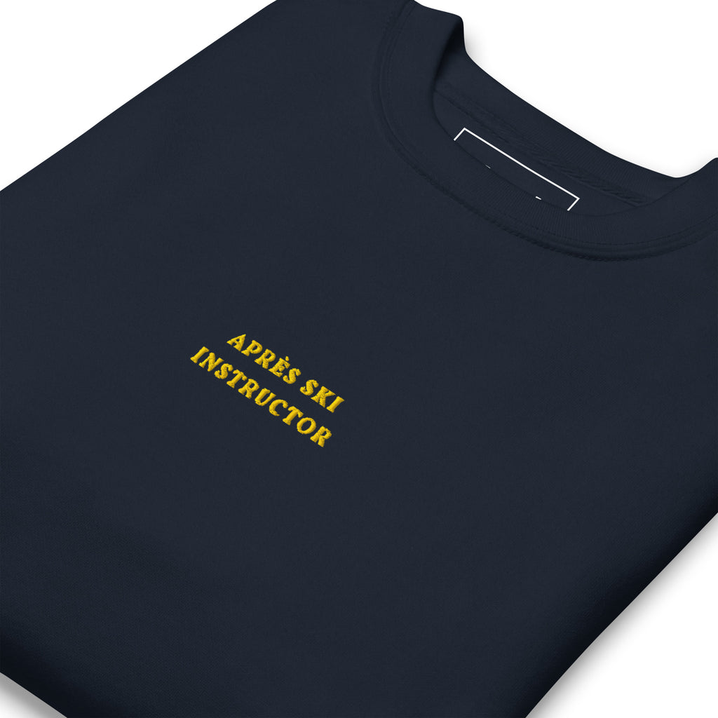 Navy Skoggl Après Ski Instructor sweatshirt with yellow embroidered chest text, fleece-lined for warmth.