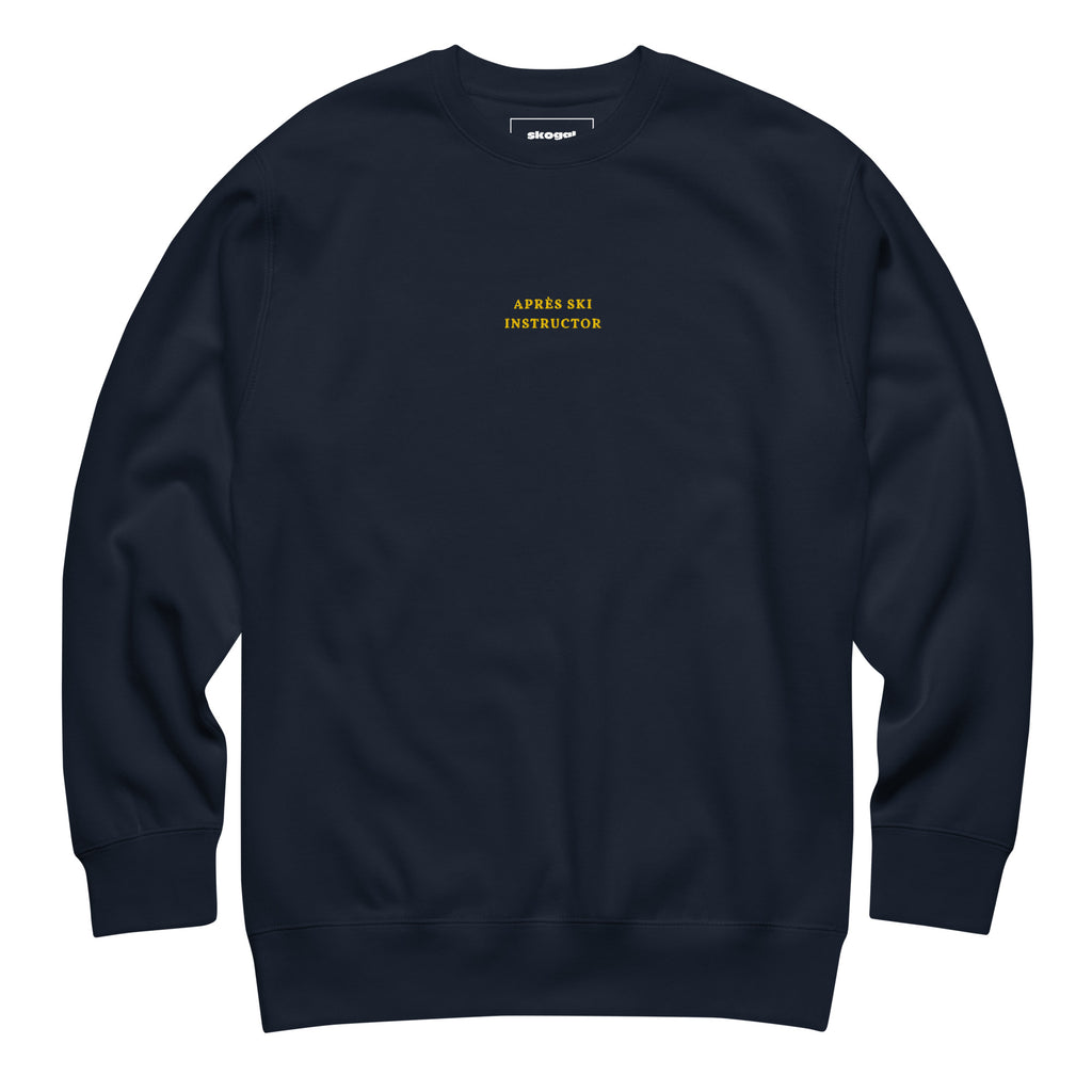 Navy Skoggl Après Ski Instructor sweatshirt with yellow embroidered chest text, fleece-lined for warmth.