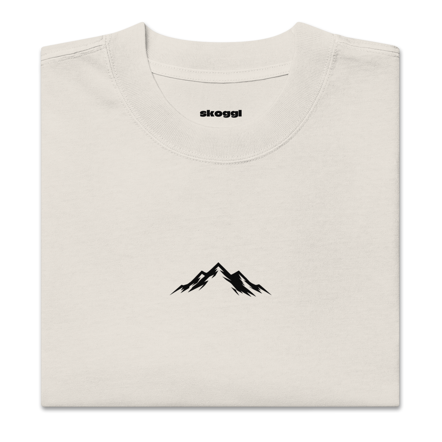 Beige t-shirt with black mountain design and 'skoggl' branding on a white background