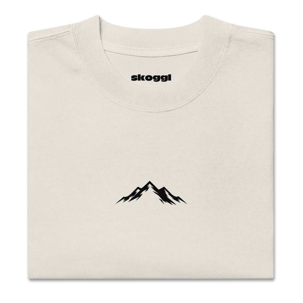 Close-up detail of the black Skoggl mountain logo printed on heavyweight 100% premium carded cotton in Washed Oat.