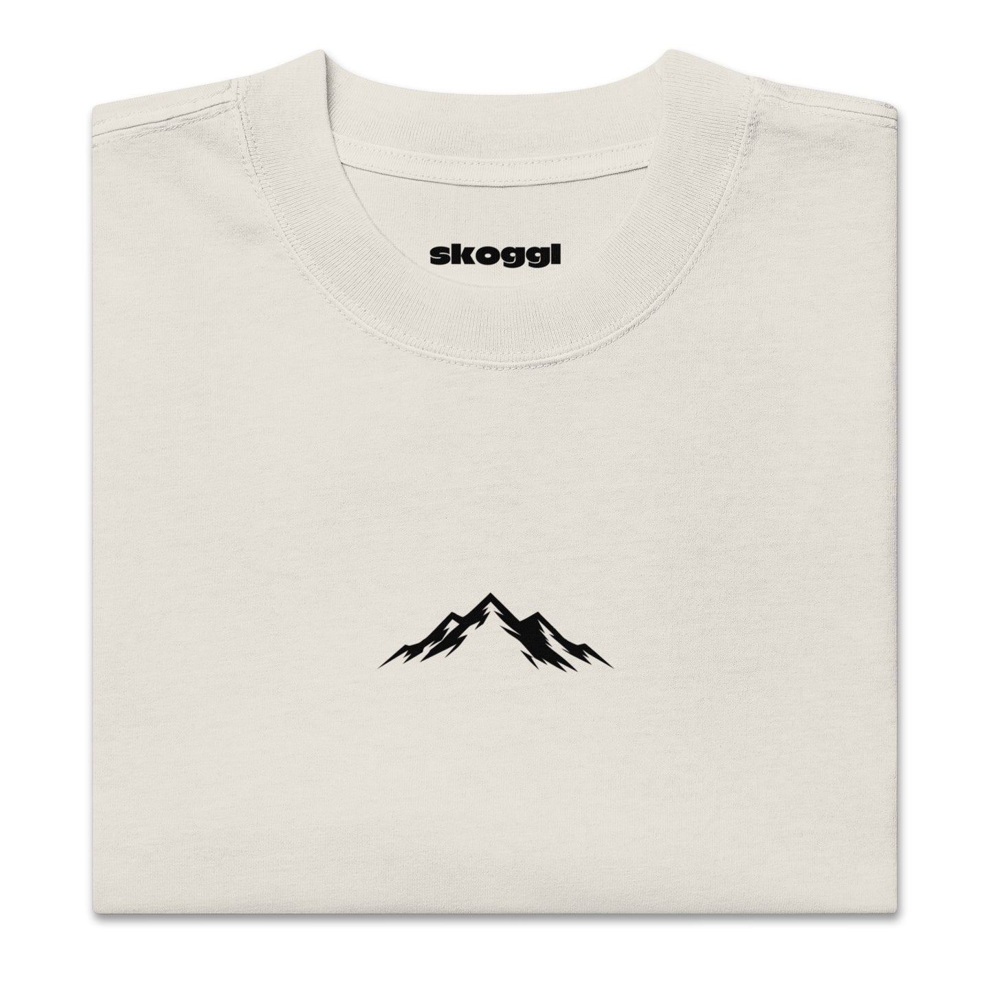 Close-up detail of the black Skoggl mountain logo printed on heavyweight 100% premium carded cotton in Washed Oat.