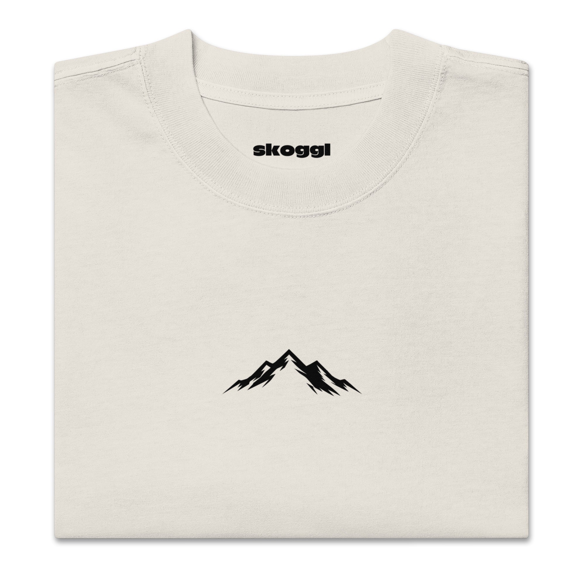 Close-up detail of the black Skoggl mountain logo printed on heavyweight 100% premium carded cotton in Washed Oat.