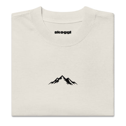 Close-up detail of the black Skoggl mountain logo printed on heavyweight 100% premium carded cotton in Washed Oat.