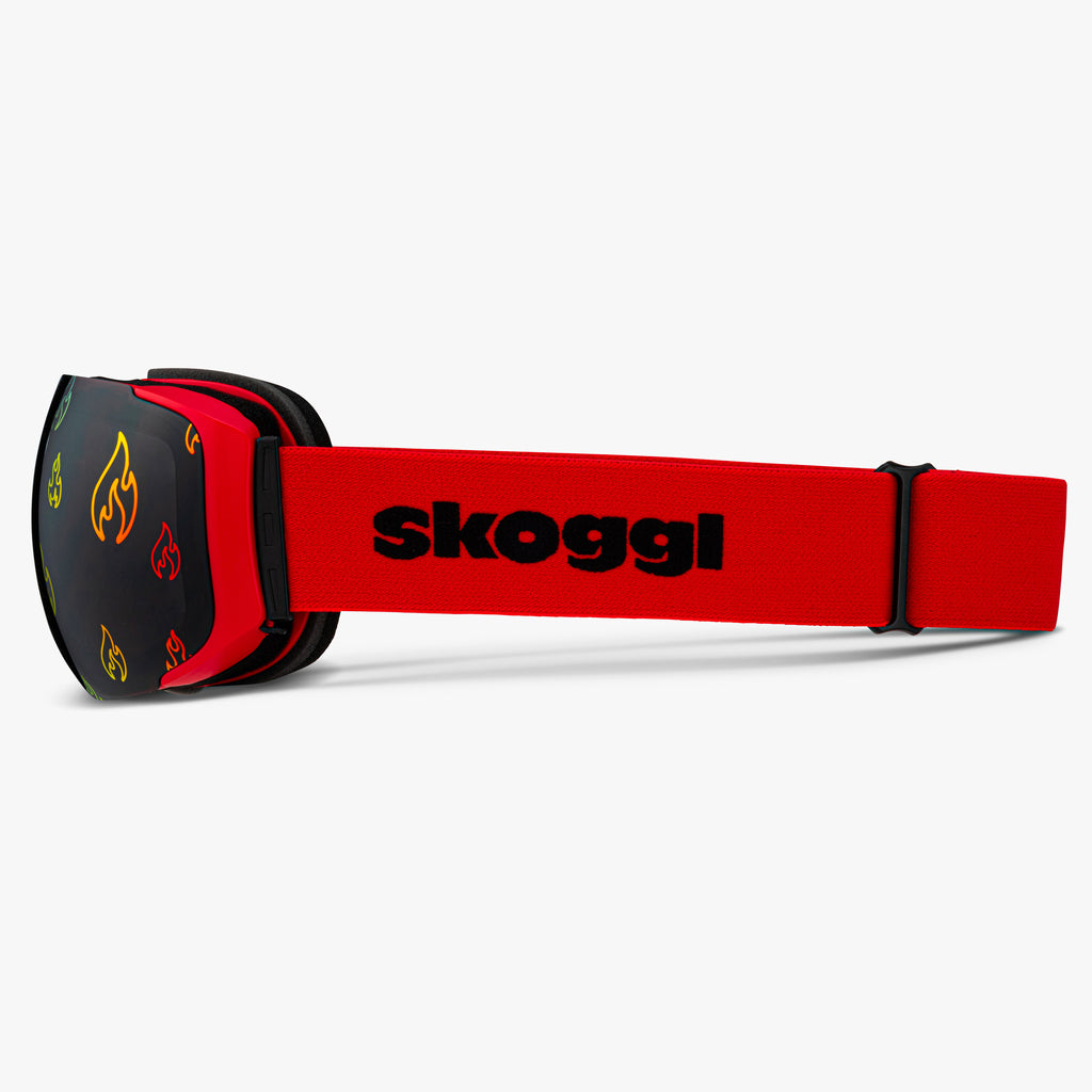 Red ski and snowboard goggles with colorful fire outlines on the lenses, showcasing bold Flame Lens designs. Features the word 'Skoggl' on the strap, highlighting customizable, magnetic goggles for style and performance on the slopes.