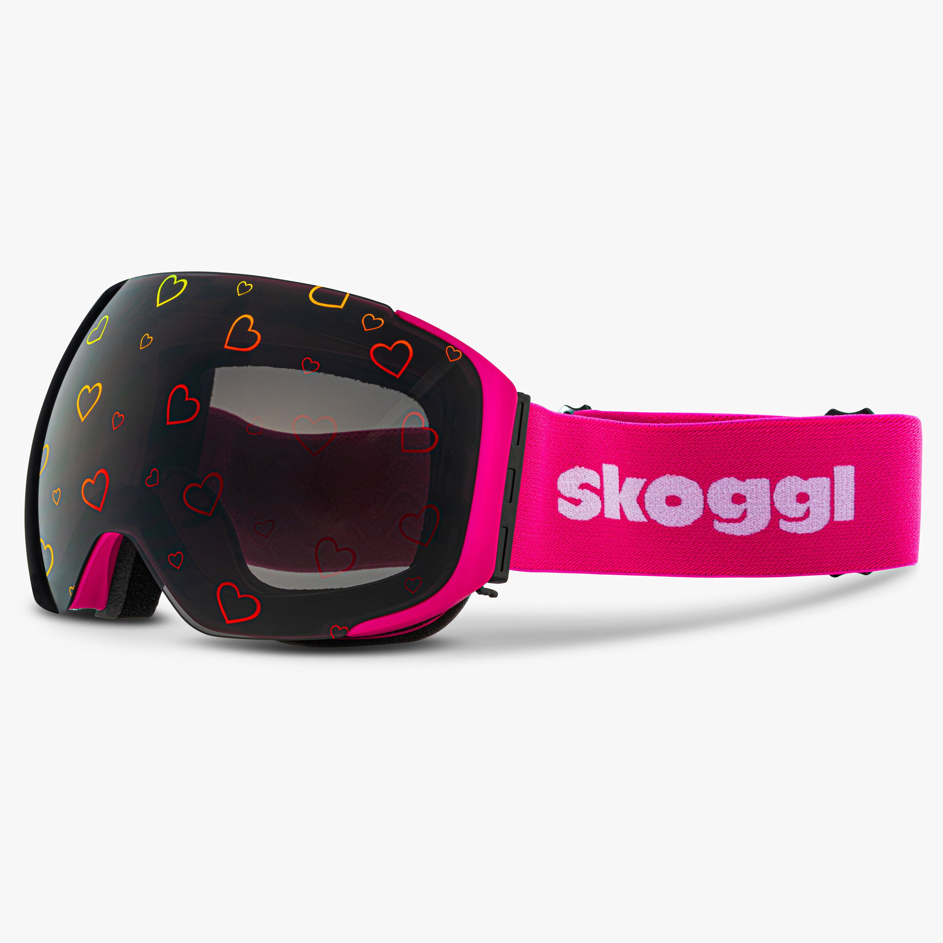 Diagonal view of Skoggl Lovefrost ski and snowboard goggles with hearts on the lens, featuring a pink frame, pink strap, and magnetic lens system for easy swaps. The playful heart design combines style and performance, making these goggles perfect for skiing, snowboarding, and winter sports.