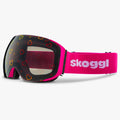 Diagonal view of Skoggl Lovefrost ski and snowboard goggles with hearts on the lens, featuring a pink frame, pink strap, and magnetic lens system for easy swaps. The playful heart design combines style and performance, making these goggles perfect for skiing, snowboarding, and winter sports.
