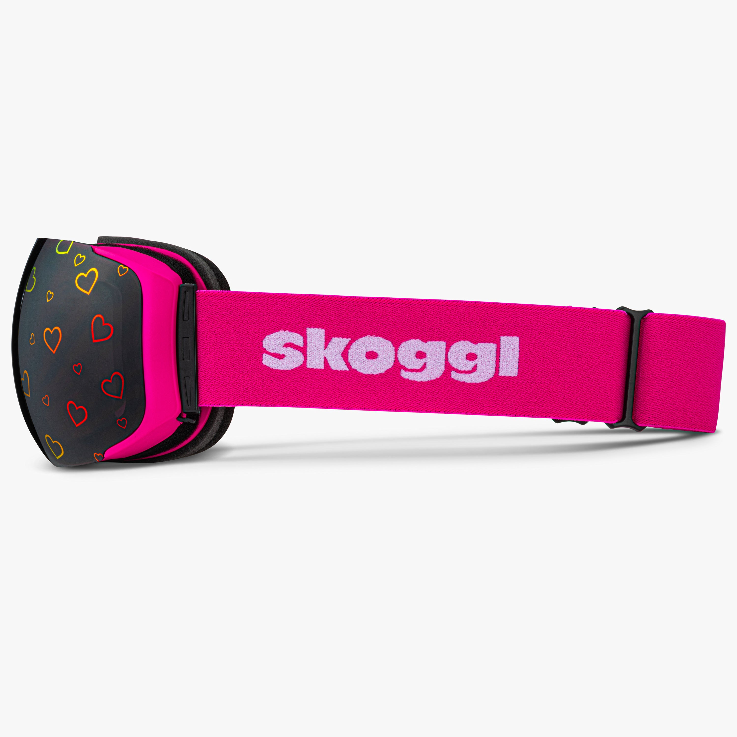 Side view of Skoggl Lovefrost ski and snowboard goggles with hearts on the lens, featuring a pink frame, pink strap, and magnetic lens system for easy swaps. The playful heart design combines style and performance, making these goggles perfect for skiing, snowboarding, and winter sports.