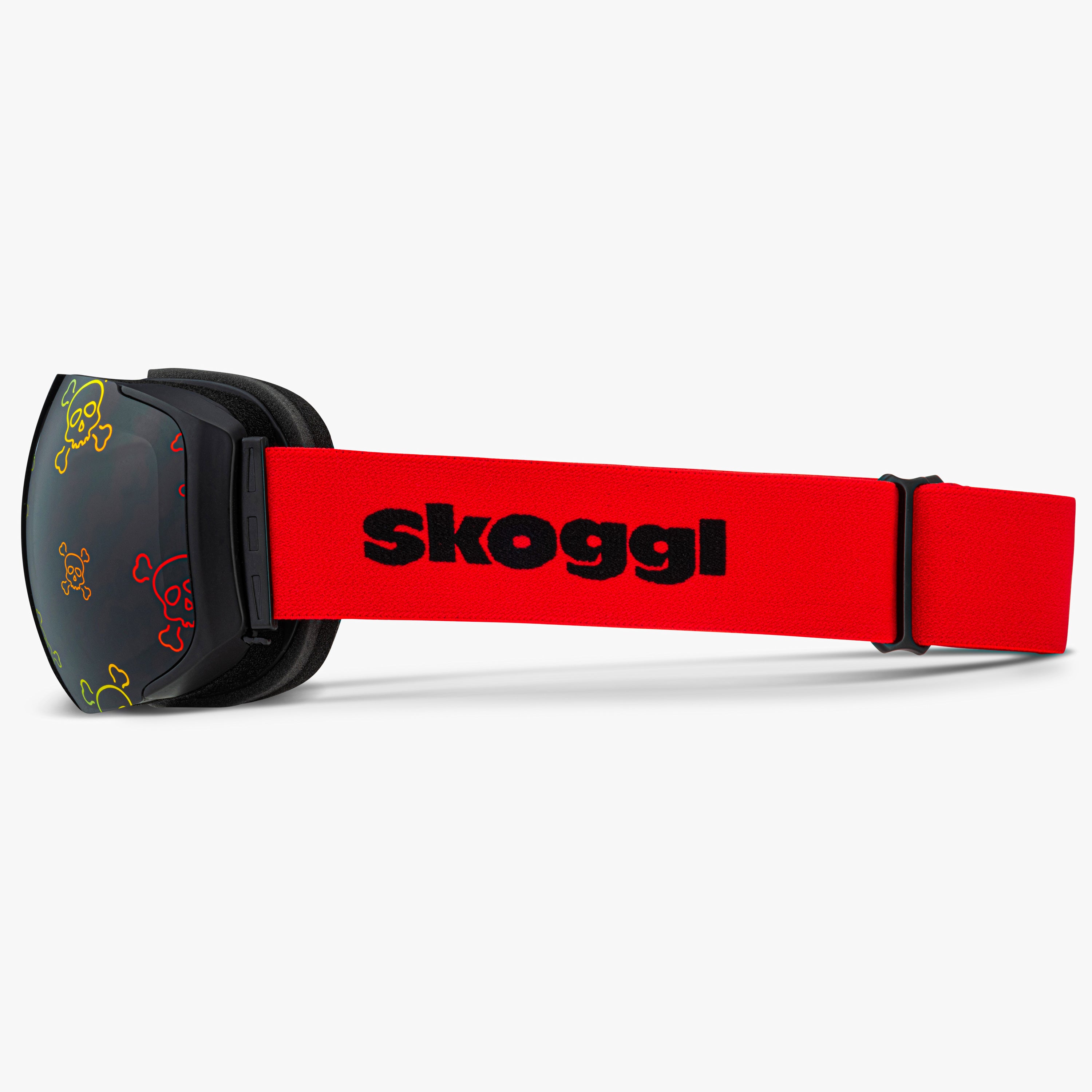Side view of Skoggl Skull Rider ski and snowboard goggles, showcasing bold skull designs on the lens, a black frame, red strap, and a magnetic lens system for easy swaps. The edgy skull pattern combines style and performance, making these goggles perfect for skiing, snowboarding, and winter sports.