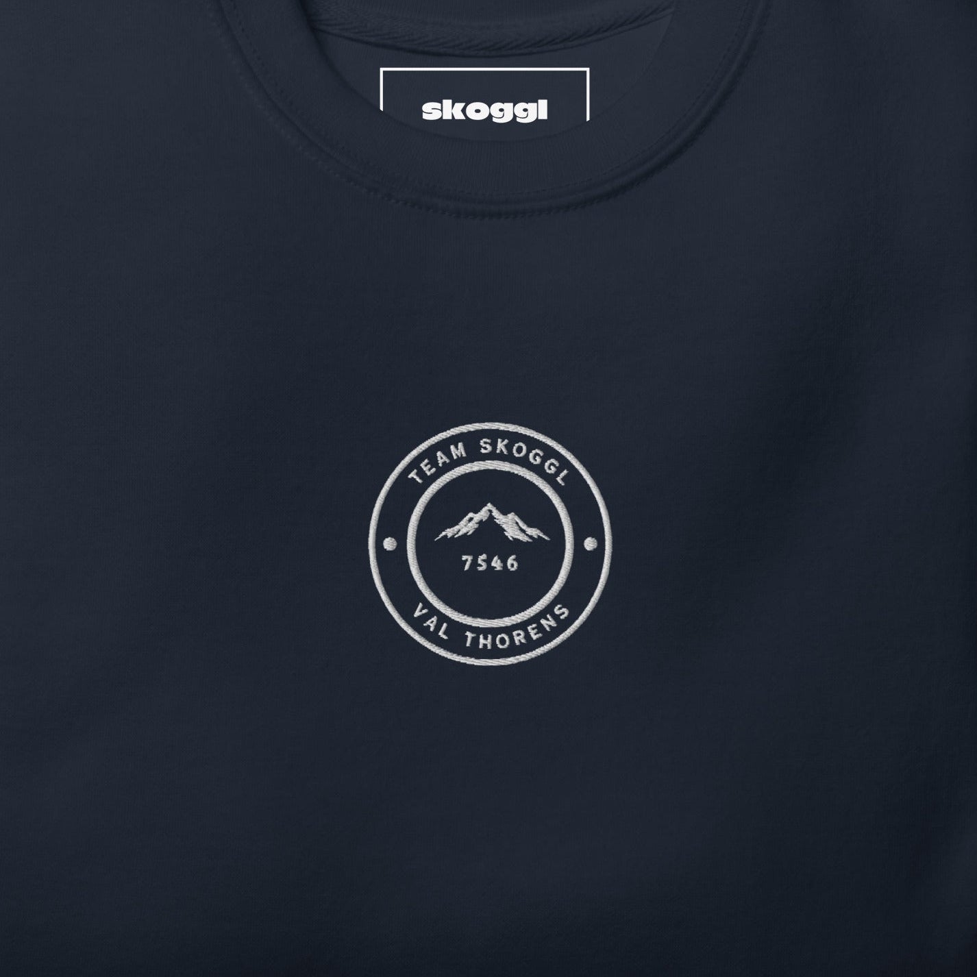 Navy blue Team Skoggl sweatshirt with white embroidered circular logo on chest, showing ‘Team Skoggl’ text, mountain design, and ‘Val Thorens’ at the bottom.