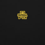 Close-up of the yellow ‘It’s Skoggl B*tch’ patch on a black hoodie.