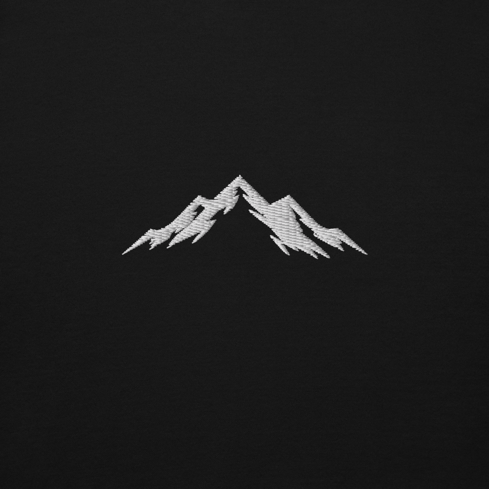 White embroidered mountain skoggl design on a black background